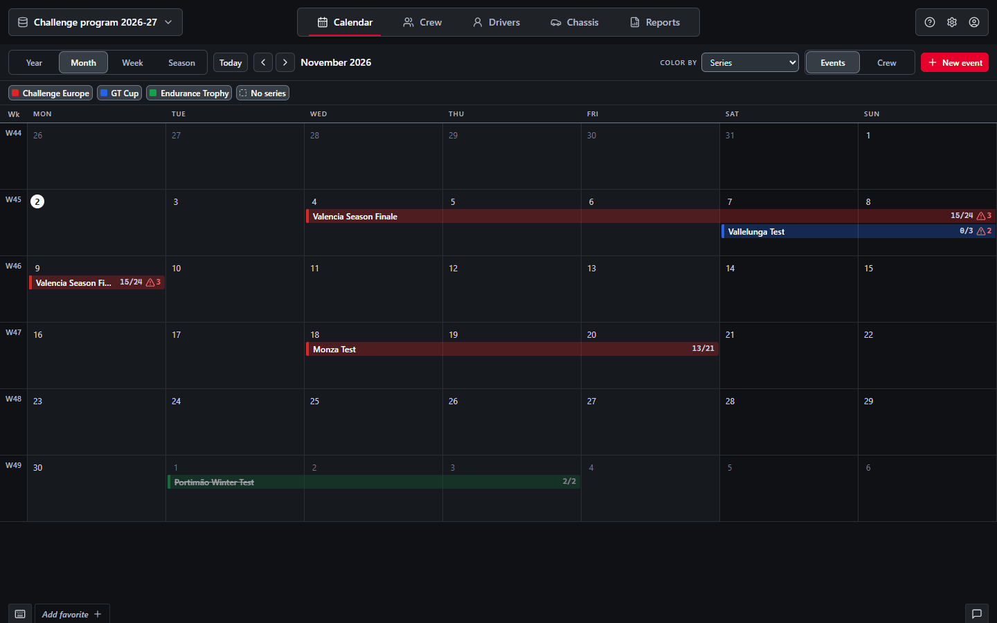 Planning Calendar, Month view of November 2026: event bars in the colour of their series, week numbers, a parallel test and a cancelled event struck through, with confirmed counts and conflict marks